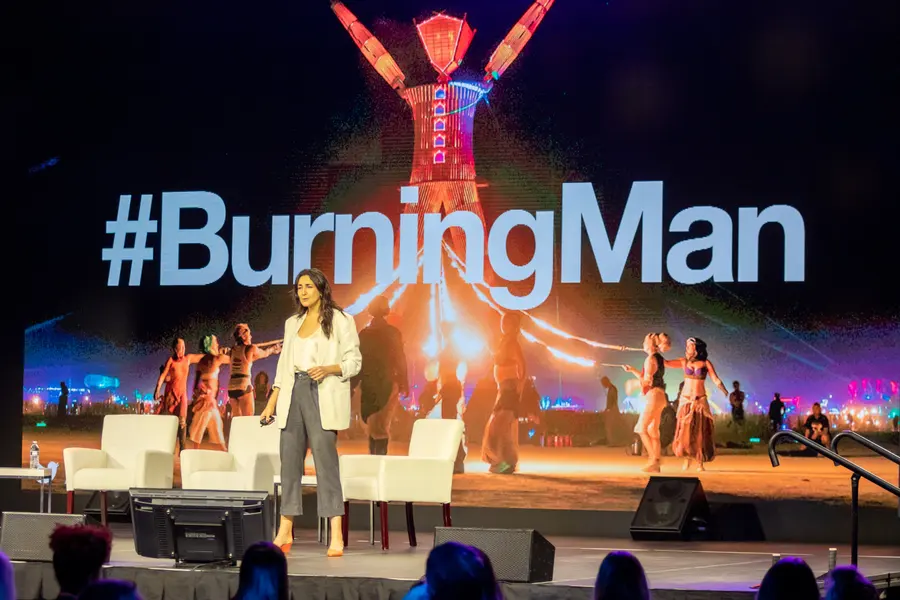 Leah Feygin presenting in front of a Burning Man slide, 2019